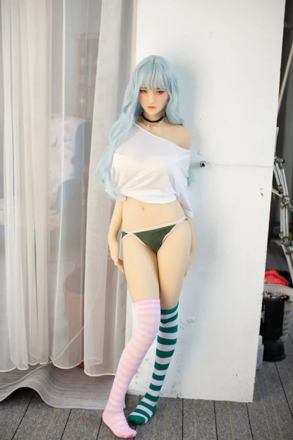 A Japanese style d-cup super realistic tpe sex doll leads against the wall.