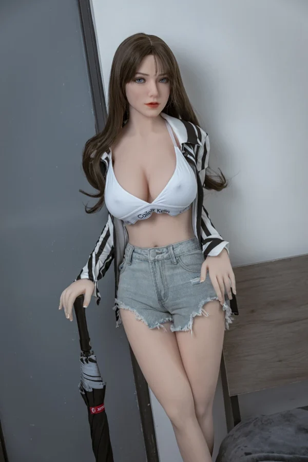 A life size big boobs e-cup ultra real sex doll leads against the wall, holding a umbrella.