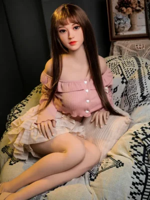 An Asian-faced sex doll with long black straight bangs sat on the couch.