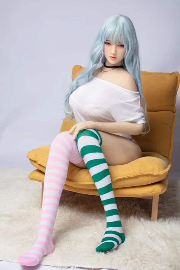 A young Asian-style sex doll sits on a chair, wearing a T-shirt and thigh-high socks.