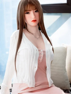 A Japanese d-cup real sex doll for man, sits on the sofa.