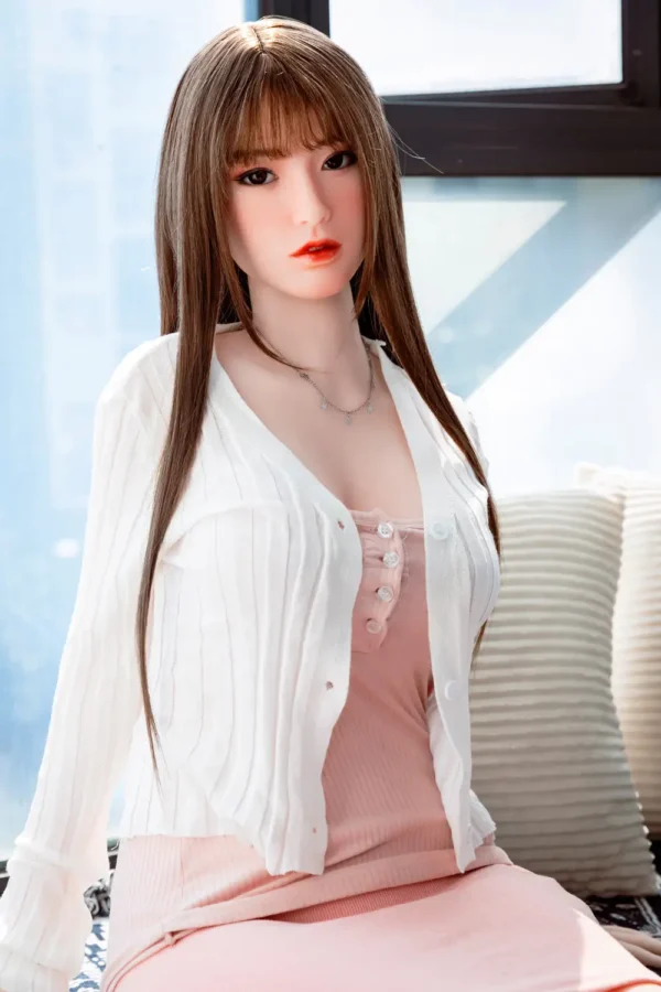 A Japanese d-cup real sex doll for man, sits on the sofa.