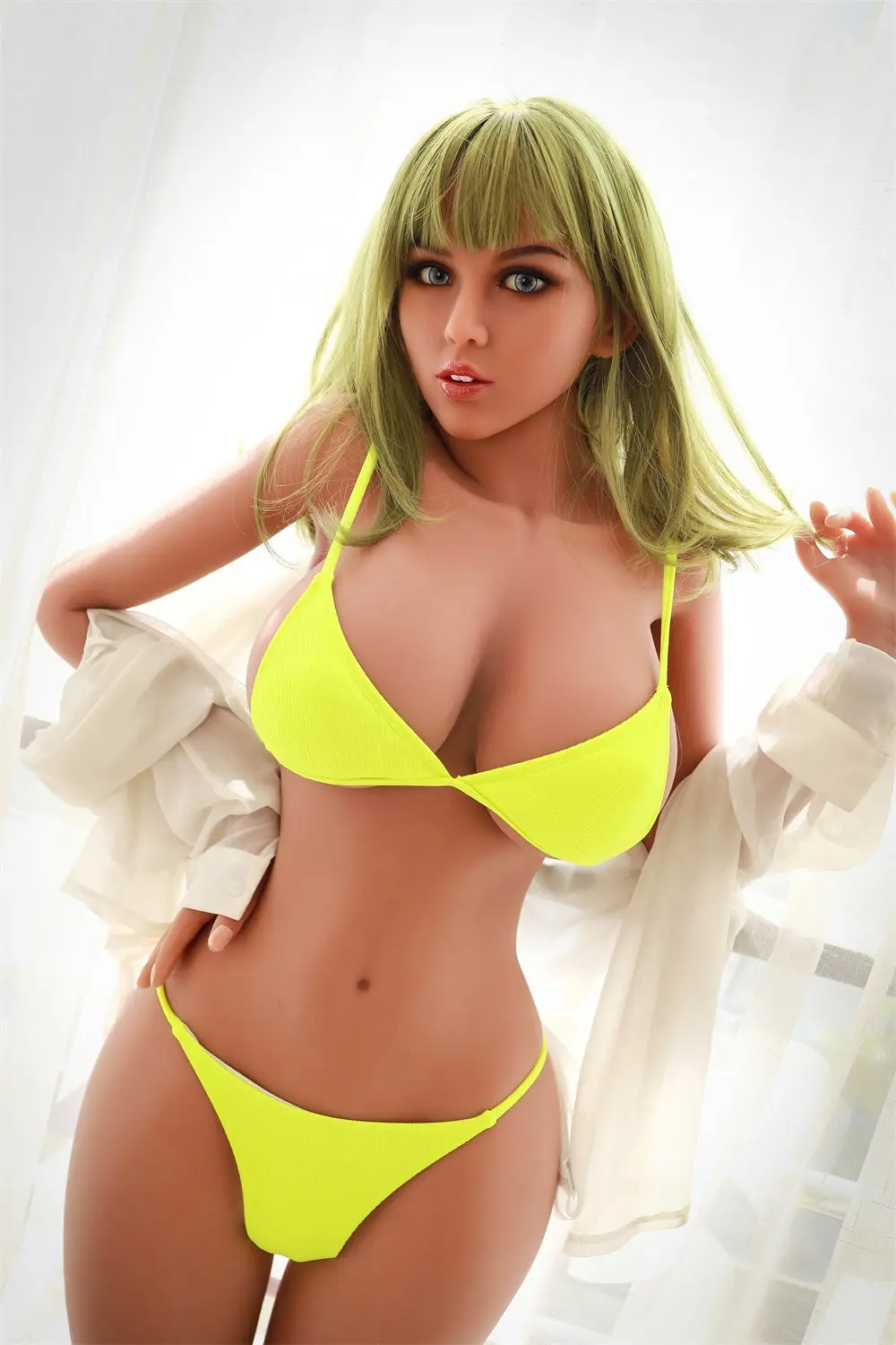 A life size leggy bikini tpe young sex doll leads against the railling, wearing a green bikini.