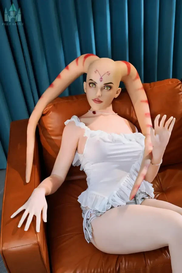 A silicone head twi'lek lekku alien sex doll lies on the sofa, wearing white shirt and denim shorts.